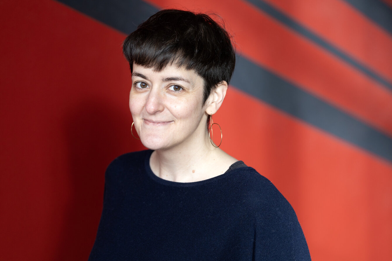 <em>Crédits : Catherine Schröder (Unistra)</em> portrait de Déborah Dubald, profil 3/4, fond rouge te noir de la cage d'escalier de l'institut d'anatomie